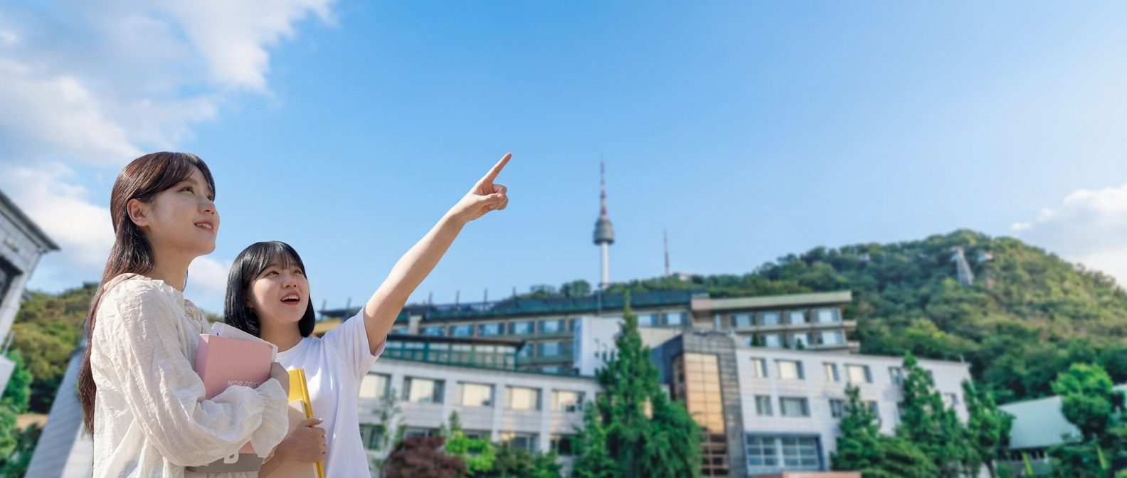숭의여자대학교 캠퍼스에서 남산타워를 가리키며 미소짓는 두 학생